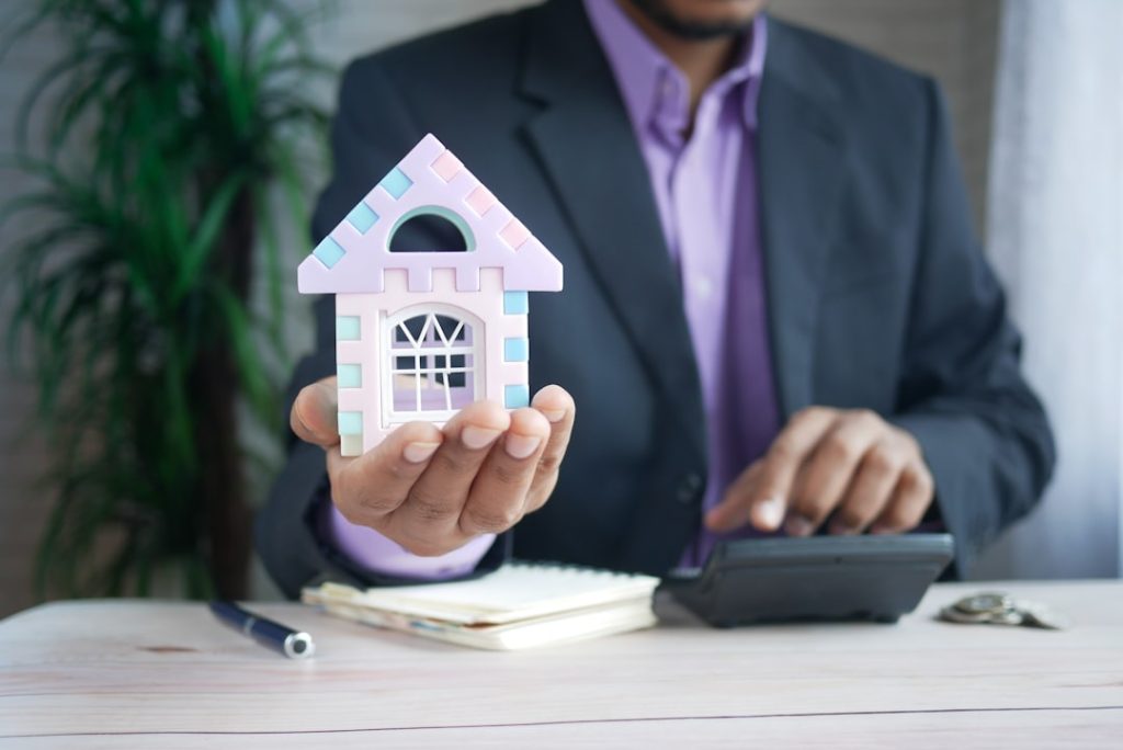 the concept of finance concept , man holding house in hand .